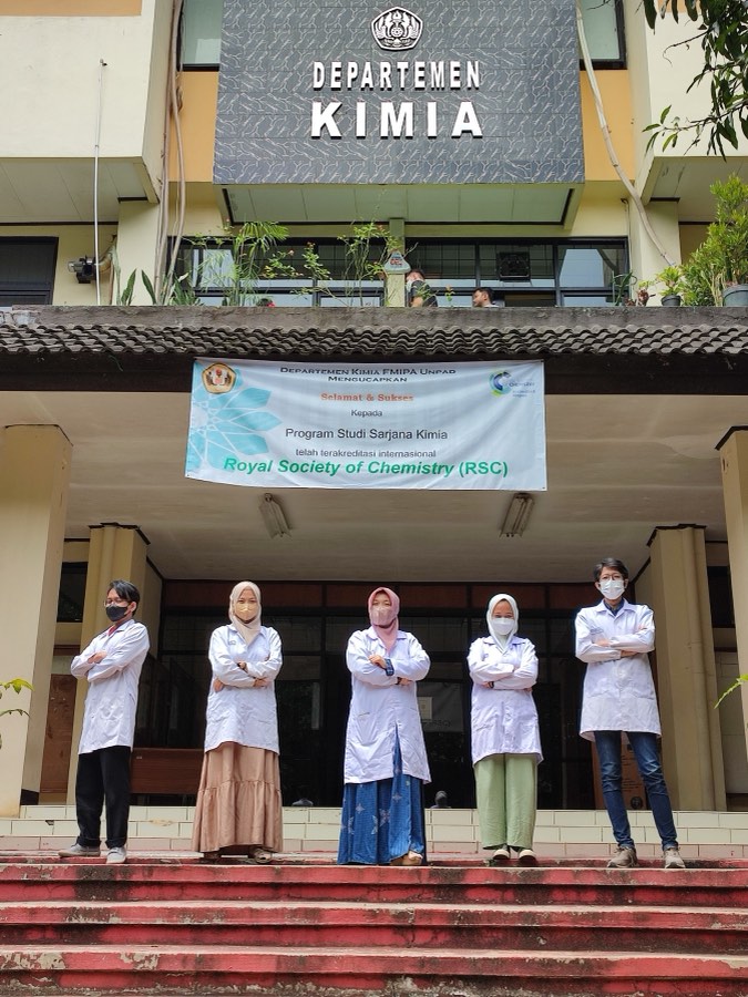 Five group members in laboratory coats outside the Chemistry Department